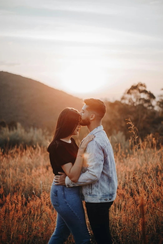 an image of a man and a woman kissing in a field