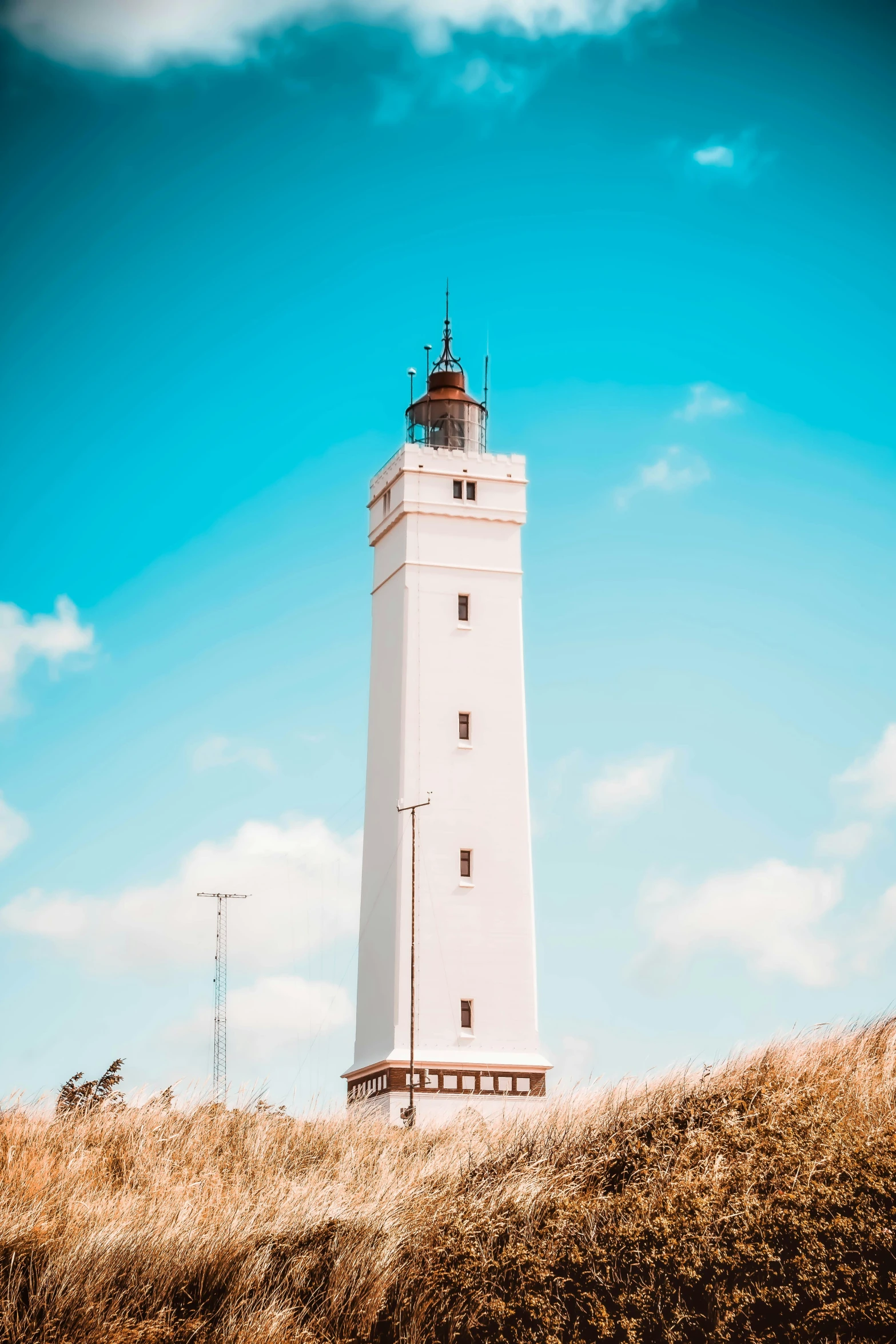 a lighthouse is shown in the foreground with a blue sky behind