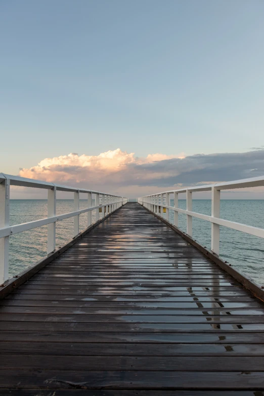 a long white pier on a wide body of water