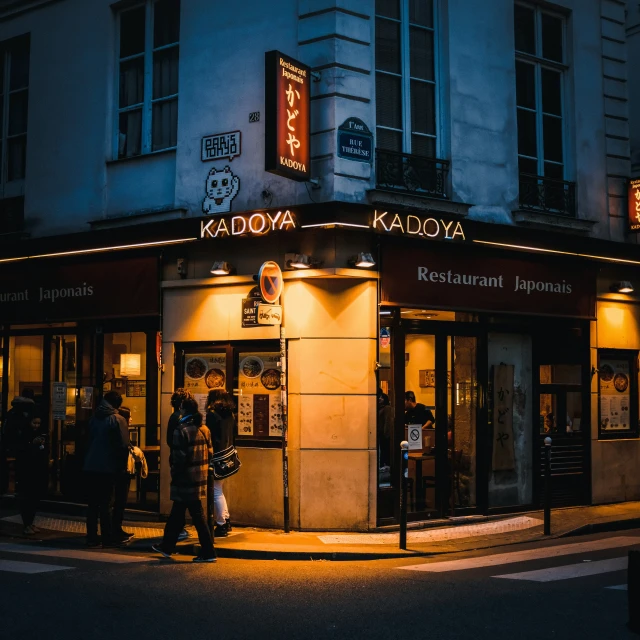 a couple of people walking down a street at night