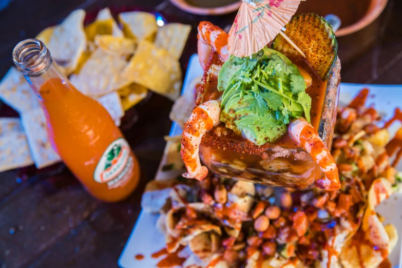 a plate of food with chips and an orange beverage