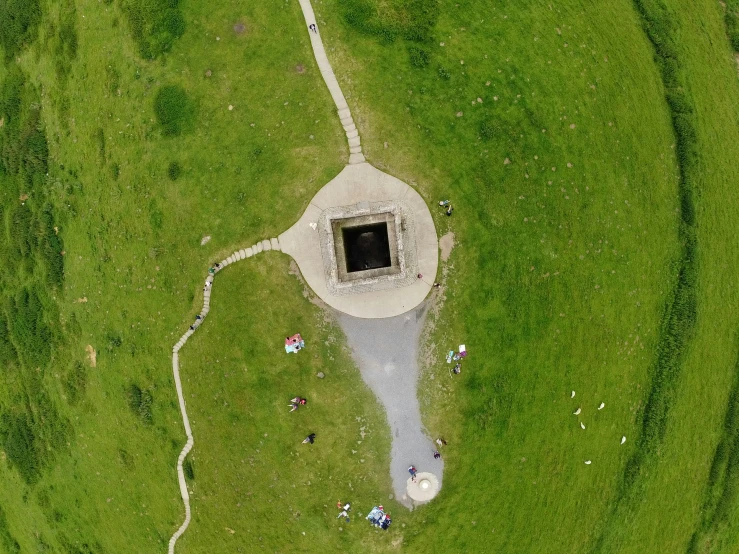 an aerial view of the field and surrounding in which people are picnicing