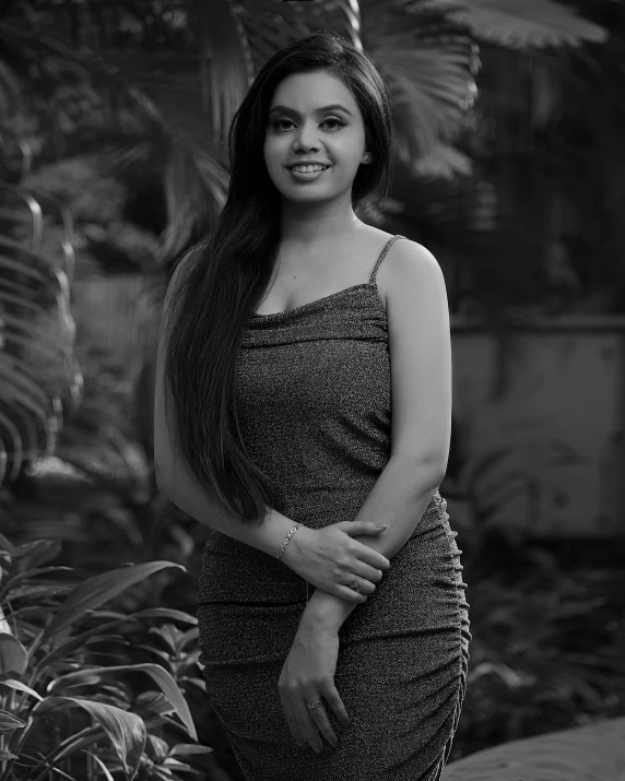 a lady smiling at the camera while wearing a dress