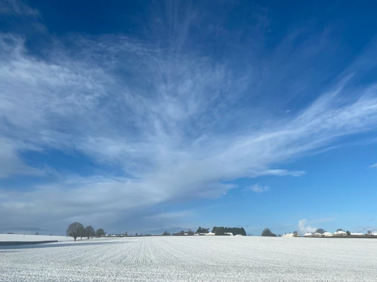 a lone bench in a wide snowy field