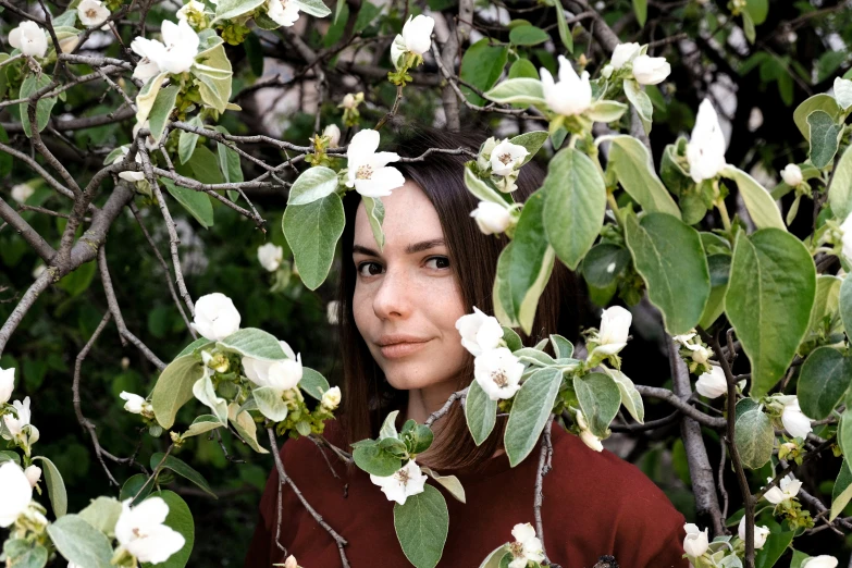 a woman is in front of some white flowers