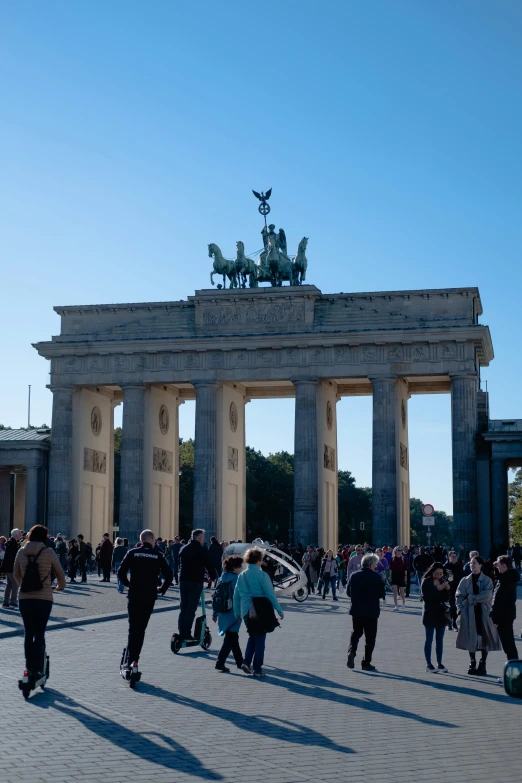 people walking around a large monument in front of a street