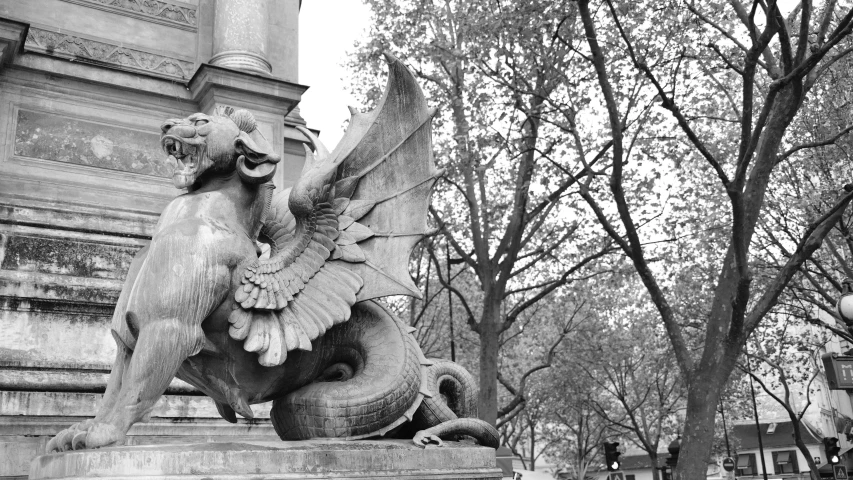 black and white pograph of a statue on the side of a building