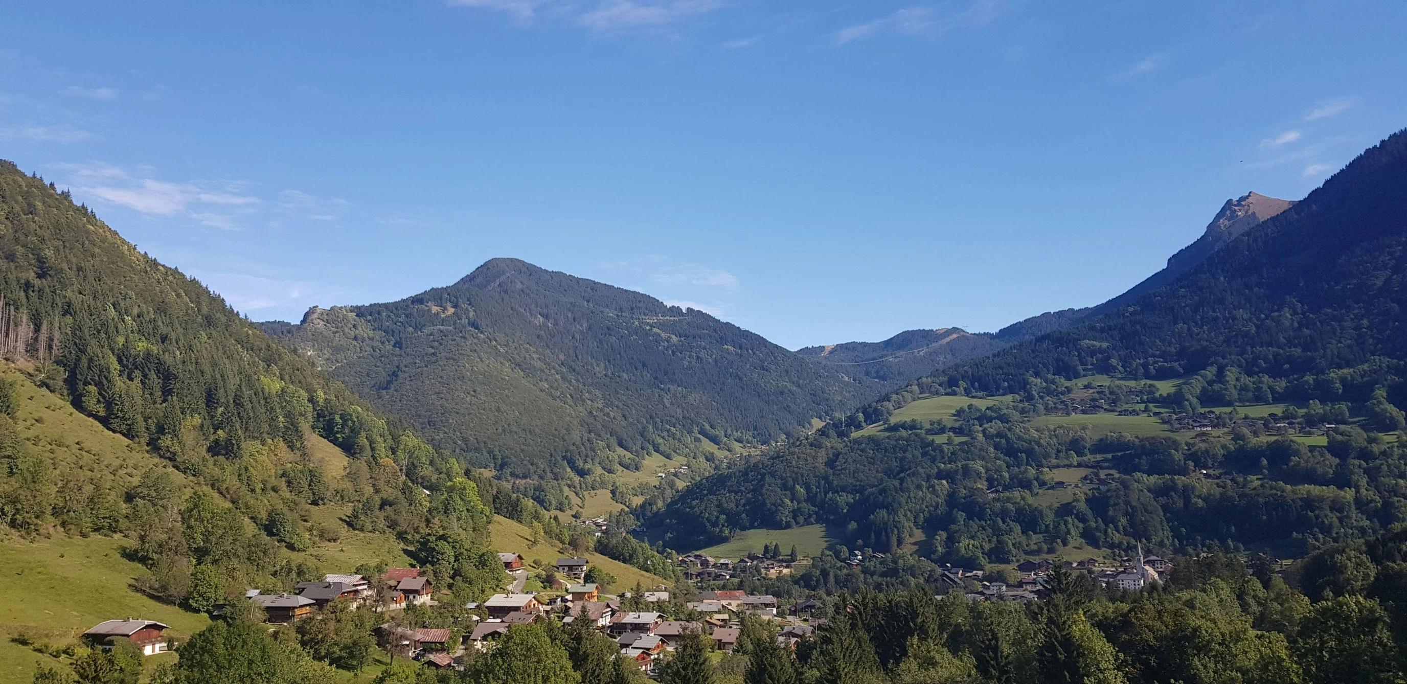 green mountains are surround houses on the hillsides