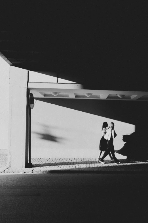 two people walk down the sidewalk with one walking