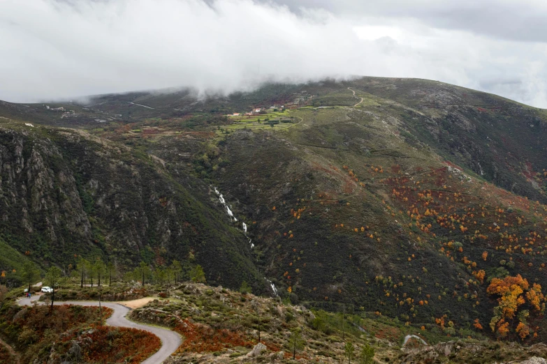 a path and a waterfall in the mountains