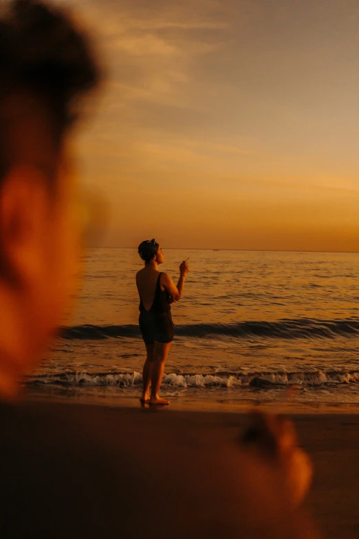 a woman is flying a kite at the beach