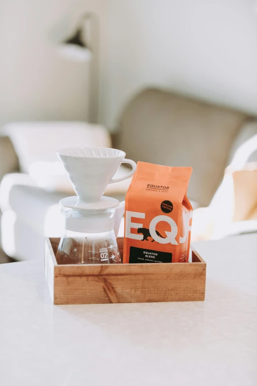 a coffee maker sitting on top of a table next to a wooden box