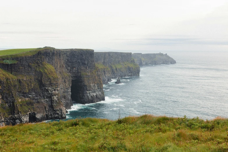 sheep are grazing on the cliffs near the water