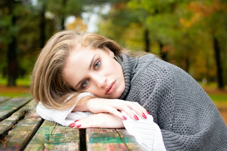 a woman sitting on a park bench with her arm wrapped