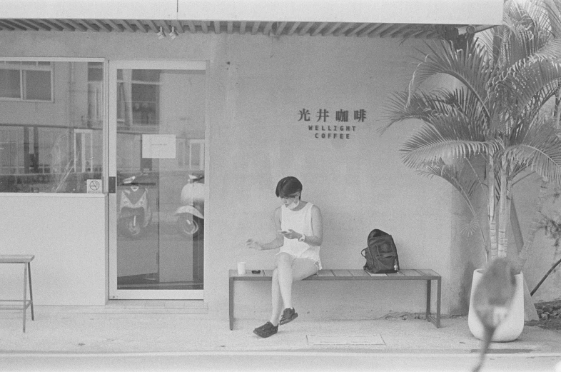black and white pograph of two men sitting outside of building