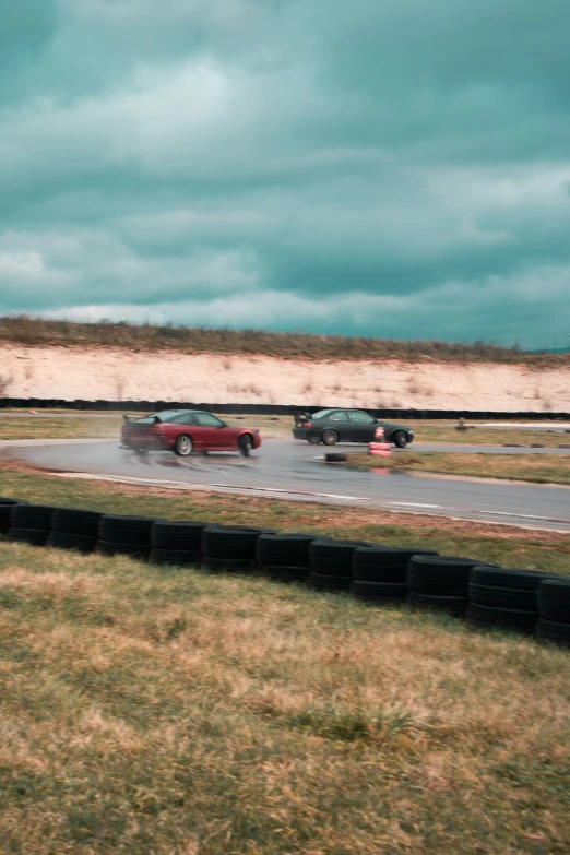 two vehicles driving in front of each other on a wet road