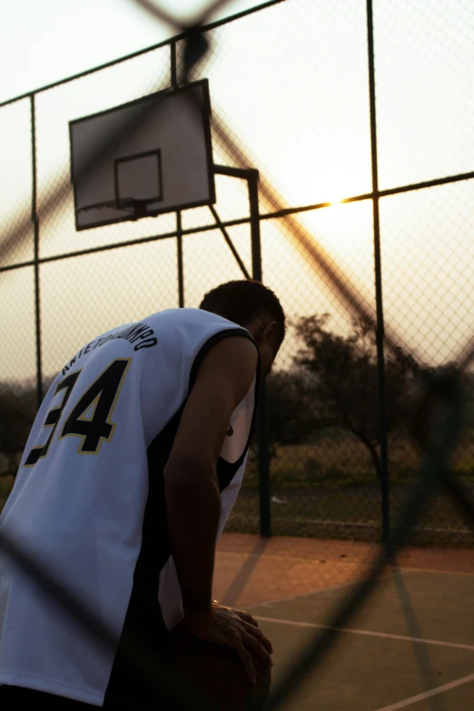 a young man is sitting on the basketball court