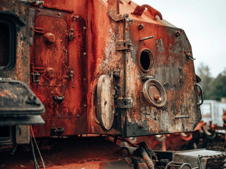 a group of rusty machinery in a factory yard