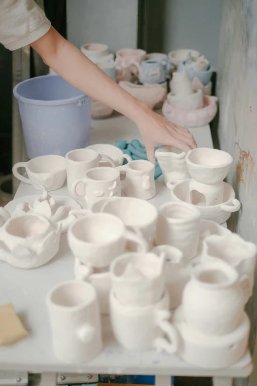 a table filled with lots of vases sitting on top of a white table