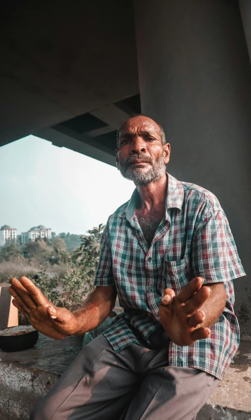 an older man sitting down with his hands folded