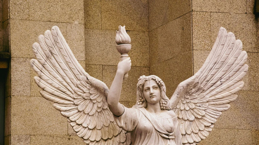 an angel statue holds a ball in one hand