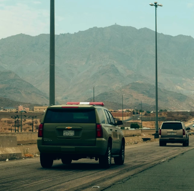 some cars are on the street near mountains