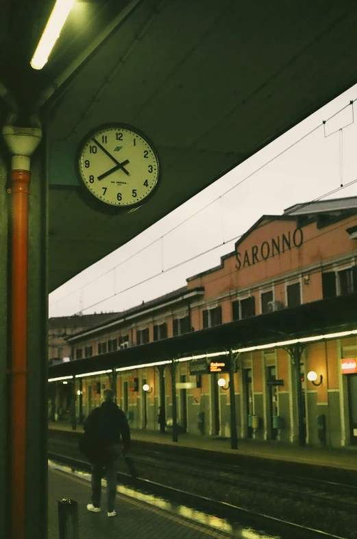 a clock is on the wall near a train station