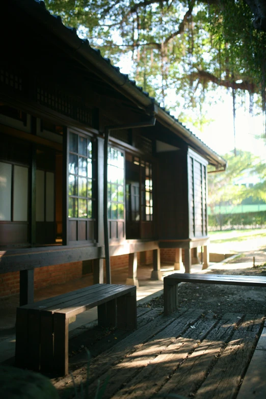 a wooden bench sits in front of an out house