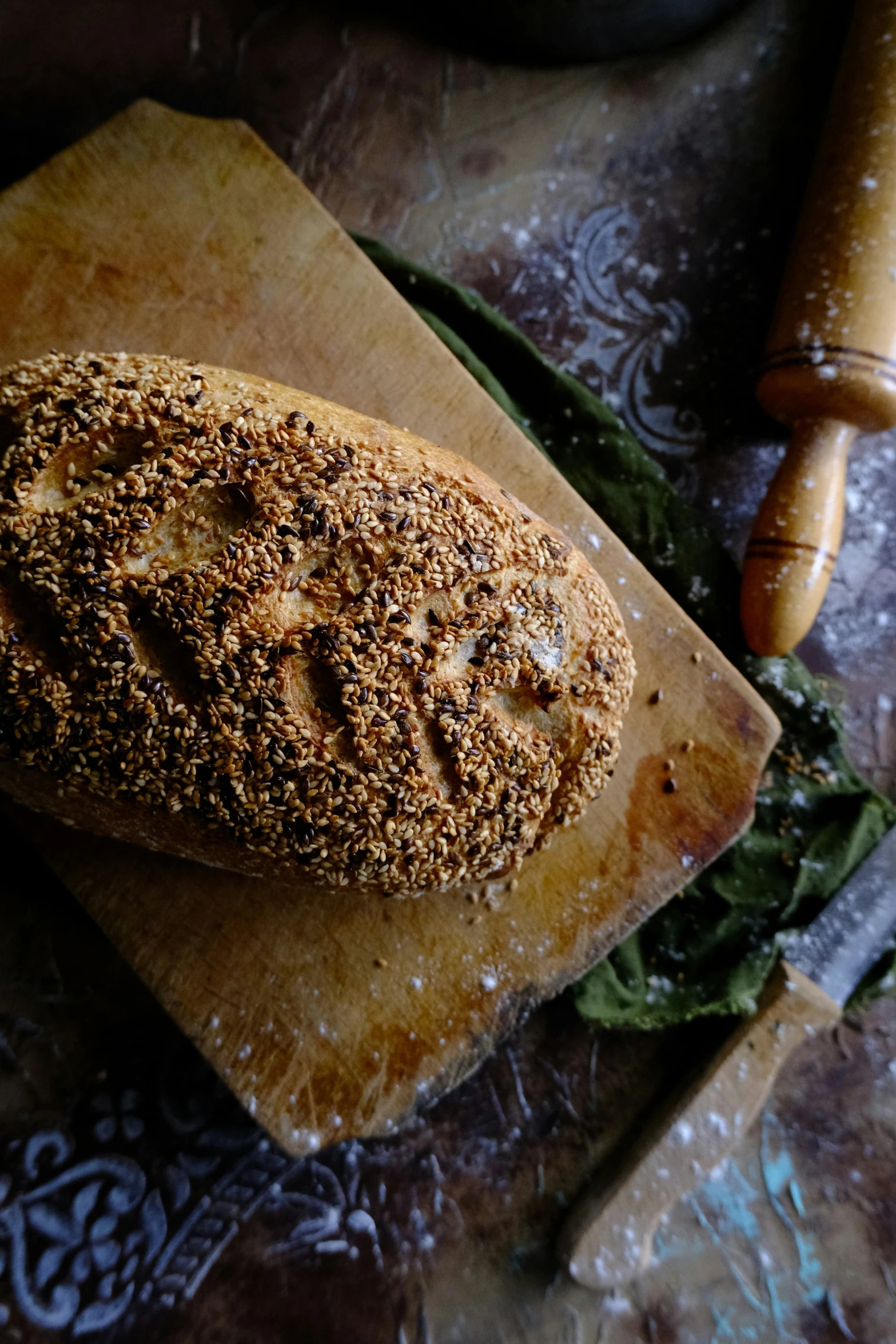 some green leafy vegetables and bread on a  board