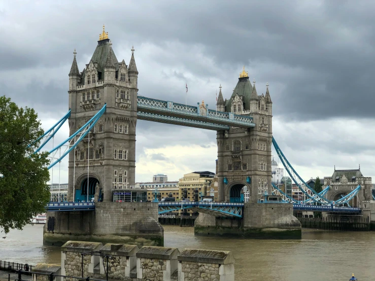 a large tall bridge over a river under a cloudy sky