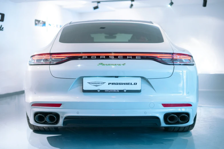 the rear end of a porsche car in a showroom