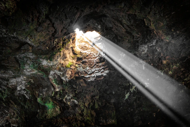 a light coming out from underneath a cave