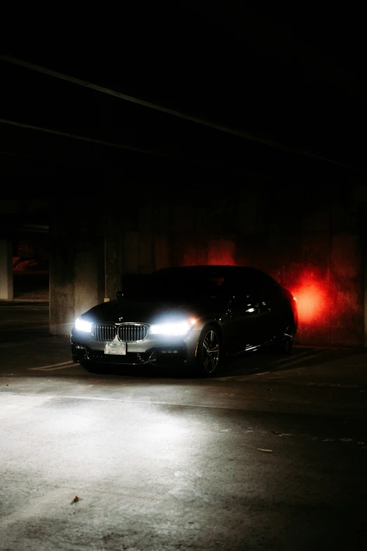 the bmw is parked in the dark under the street lights