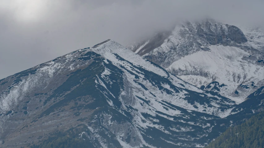 mountain with many snow and low clouds