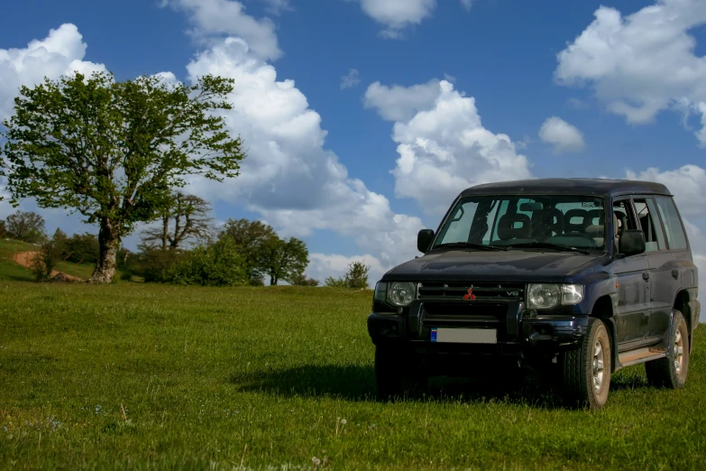 the small car is parked in the field