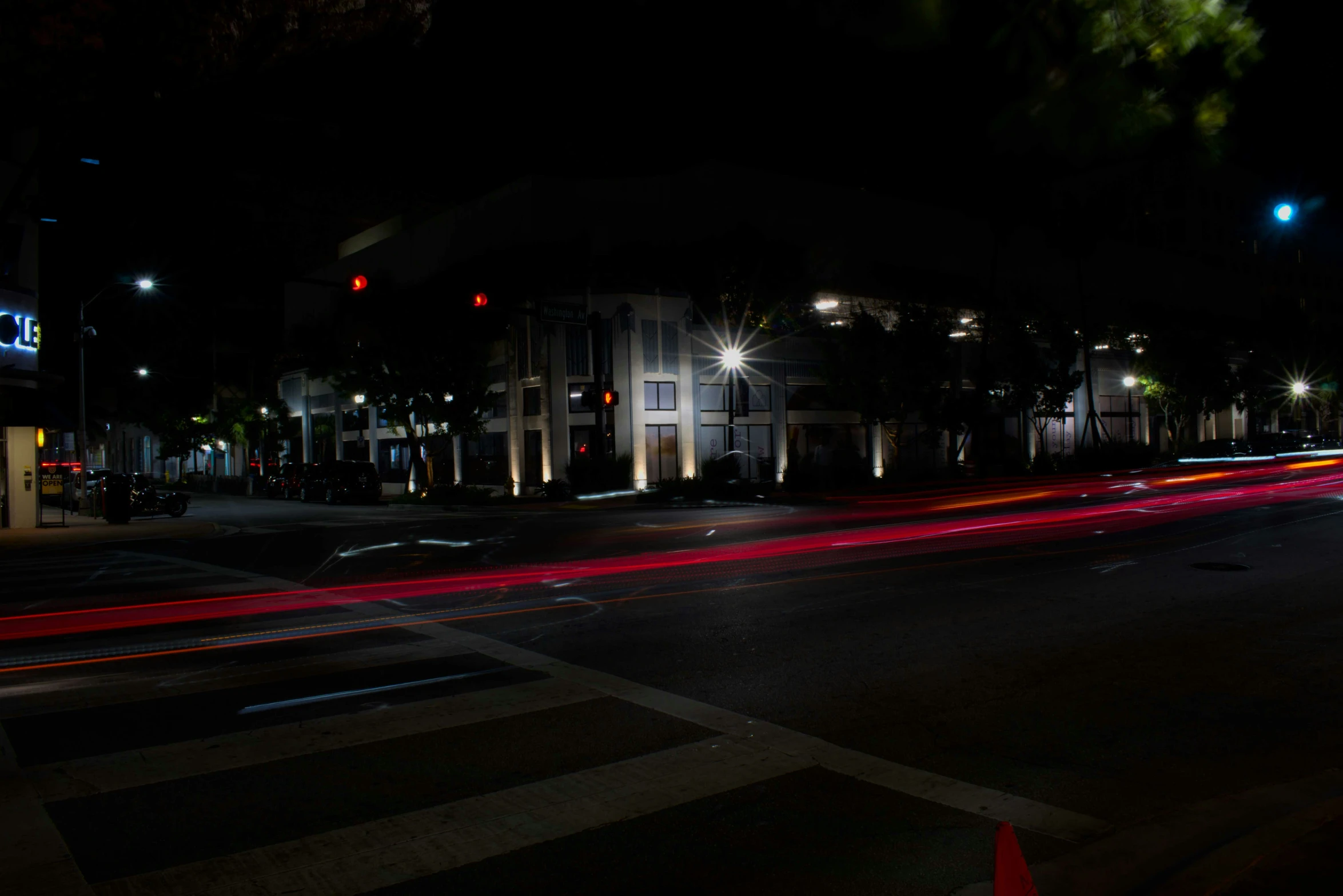 street lights in the night with the crosswalk painted red