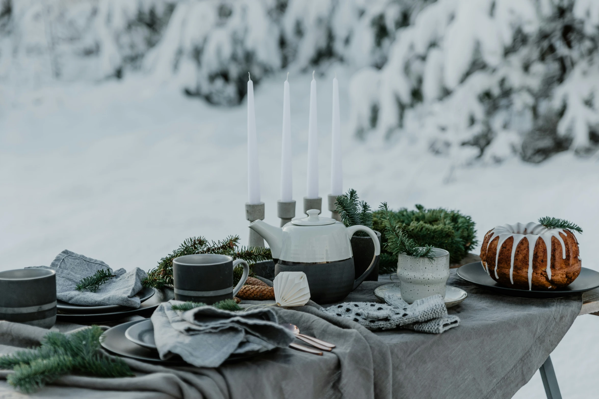 a table with candle holders, plates and desserts on it