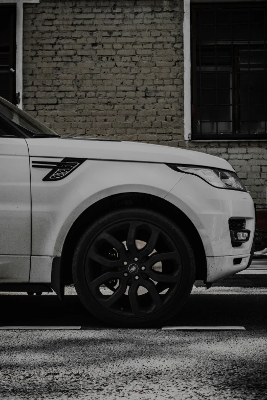 a white range rover is parked on the side of the road