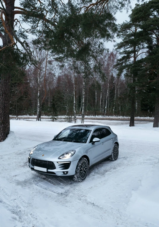 a silver car driving through snow covered ground