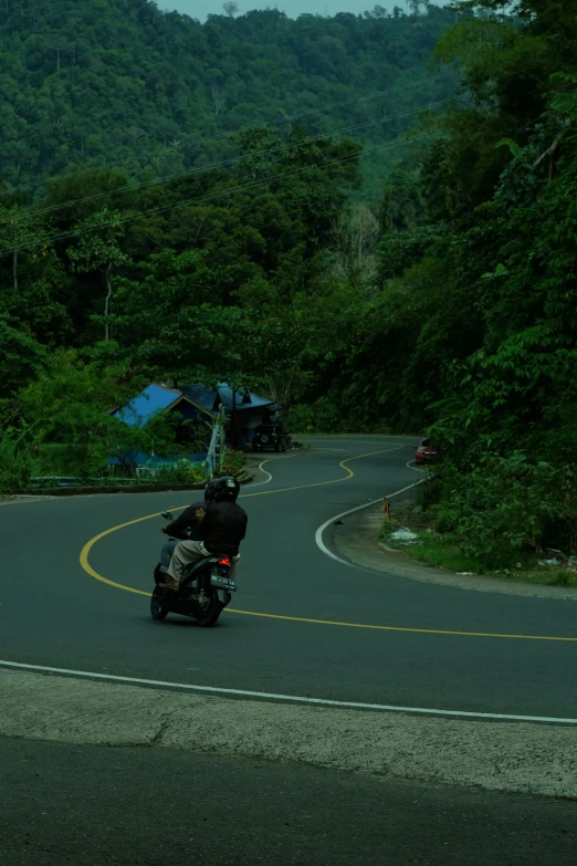 there is a person on a motorcycle riding down the road