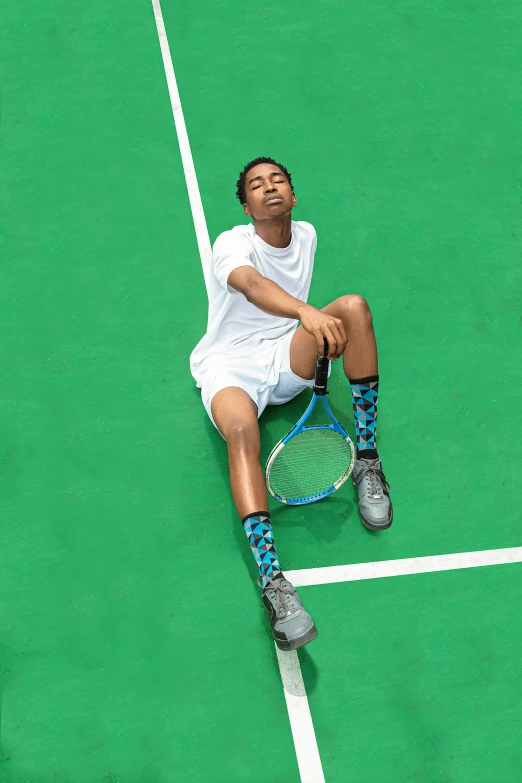 a person sitting on a court holding a tennis racket