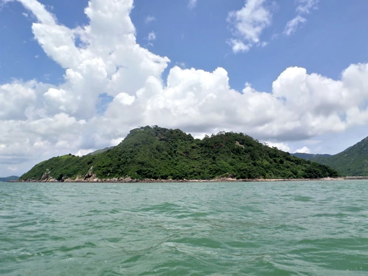 a beach with a lot of water and green hills in the background