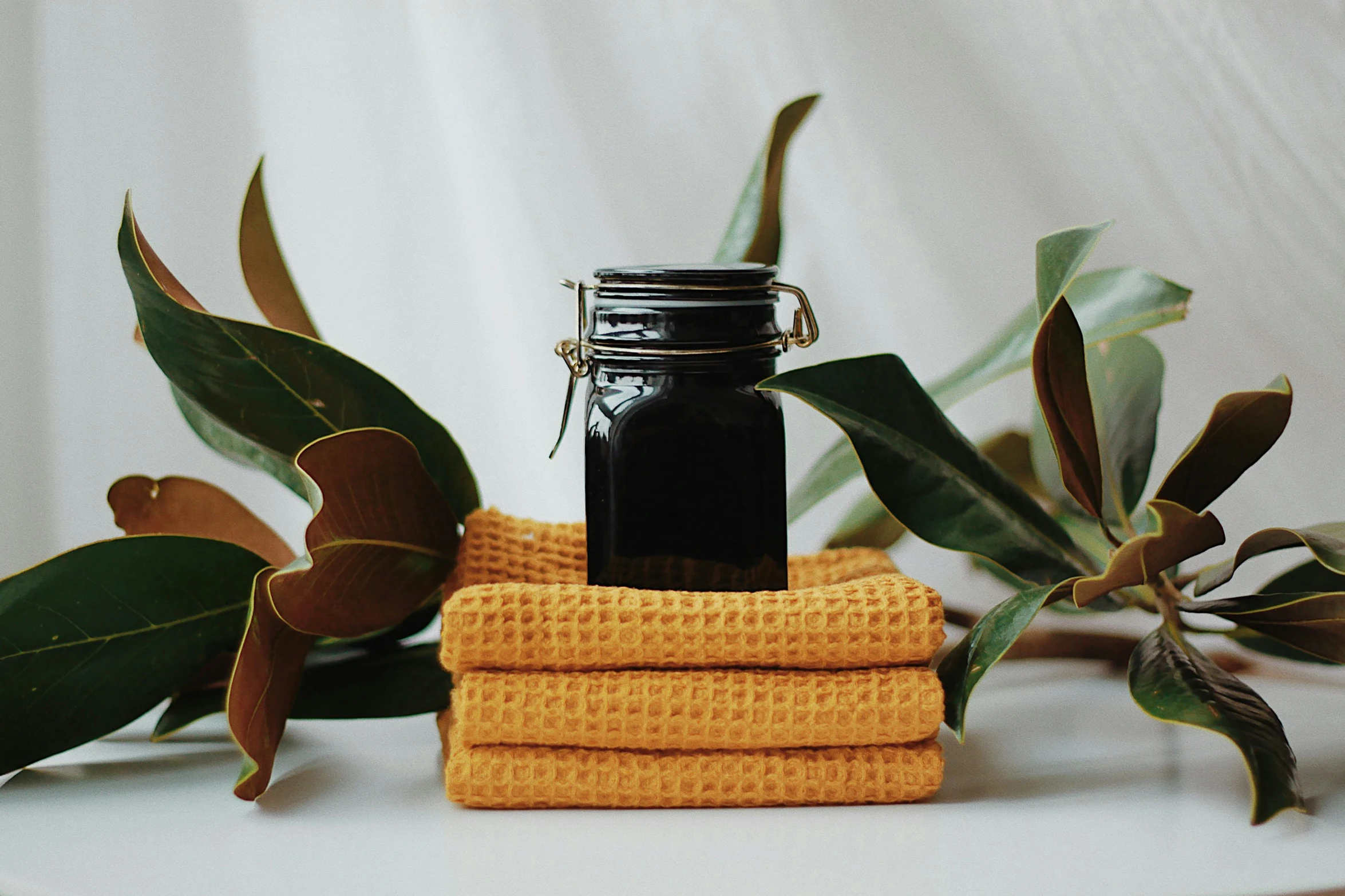 bottles of oil and orange cloths placed on a table