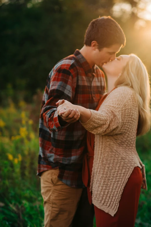 a woman kissing a man in the middle of a field