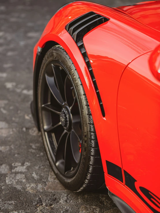 the wheel trims on a sports car's shiny red paint