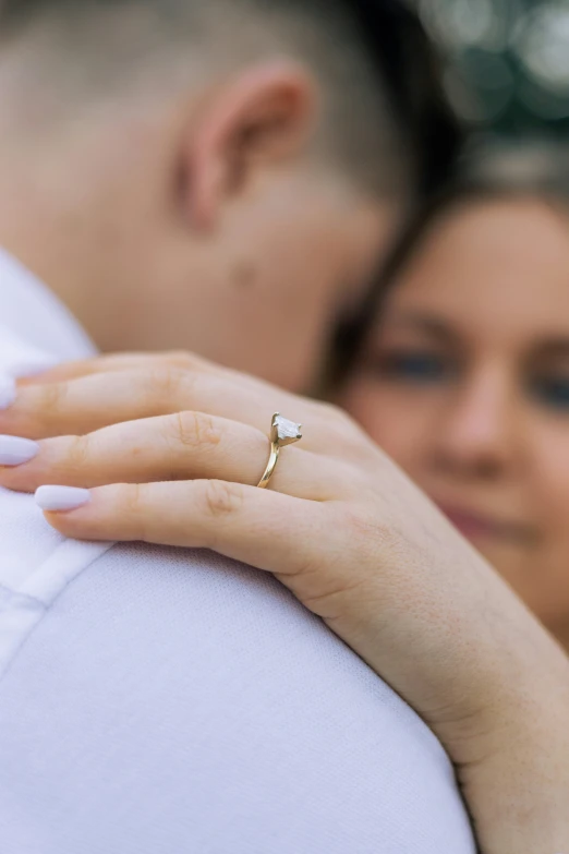 a couple emce during their engagement session with a ring on his shoulder