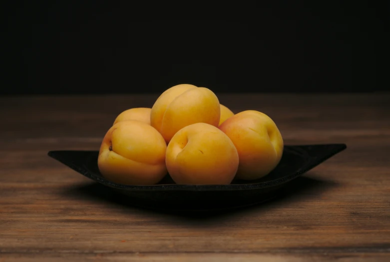 four pieces of fruit sitting on top of a bowl