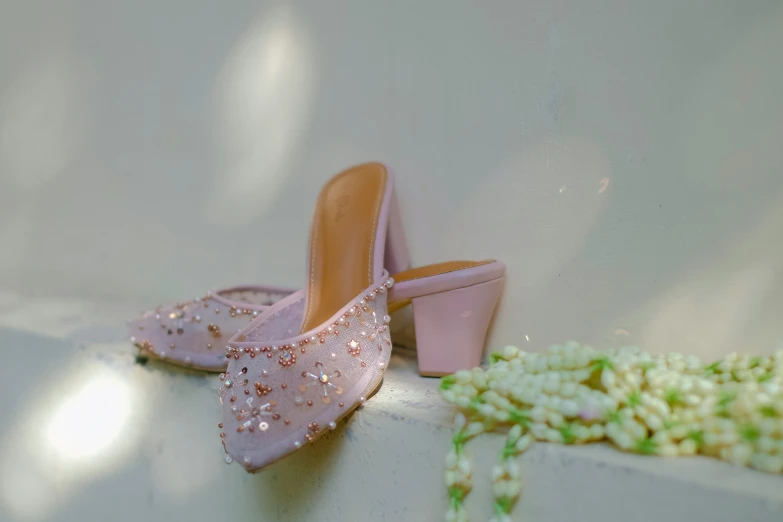 a pair of pink high heel shoes laying on top of a white surface