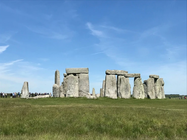 a large stone monument in the middle of a grass field