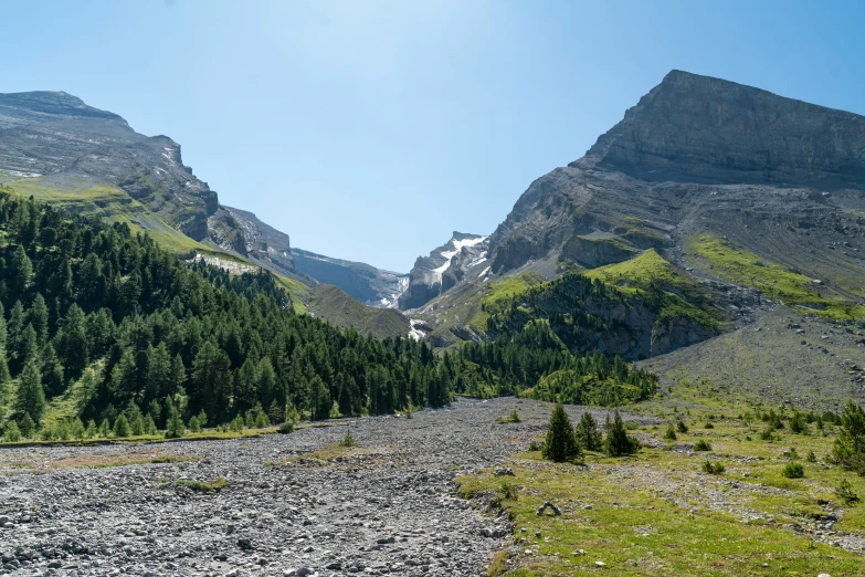 a train on a rocky road going through a mountain range